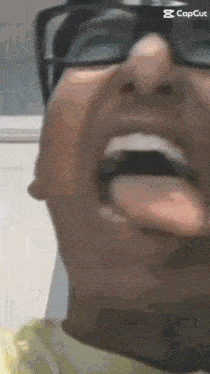 a close up of a man 's face with his tongue out .