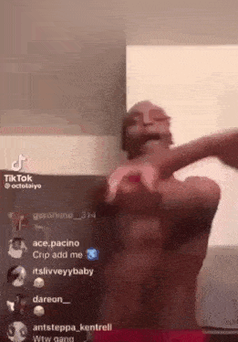 a man without a shirt is dancing in front of a camera on a tik tok video .