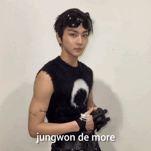 a young man wearing sunglasses and a black vest says jungwon de more on the bottom