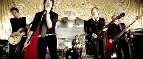 a group of men playing guitars and singing on stage