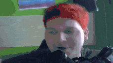 a man with red hair is wearing a black jacket