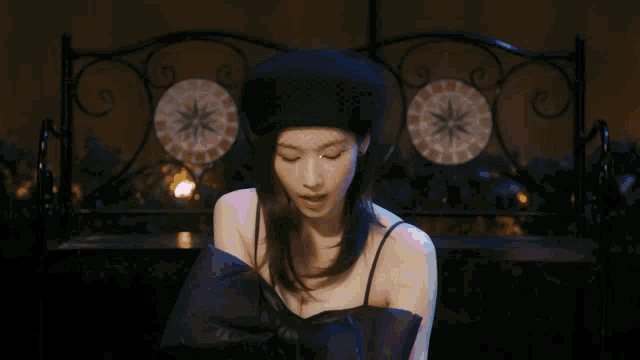 a woman wearing a black hat and gloves is making a funny face