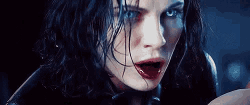 a close up of a woman 's face with blood on her face and red lips .