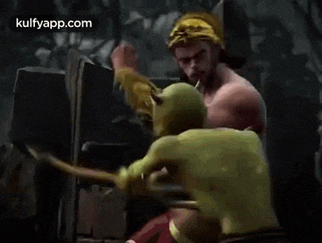 a man with a crown on his head is fighting another man with a green face .