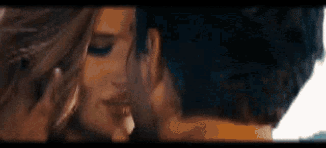 a man and a woman are kissing each other in a close up of their faces .