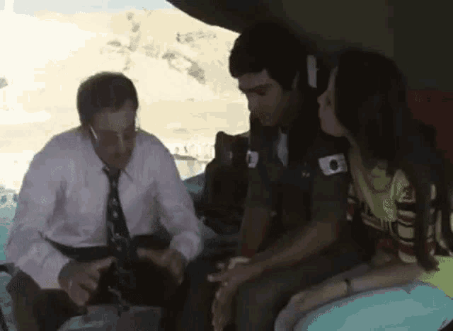 a man and a woman are sitting in a car and talking to each other .