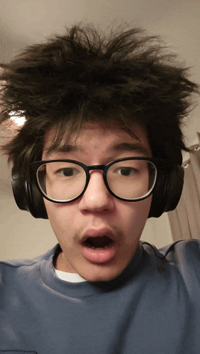 a man wearing glasses and headphones is making a funny face