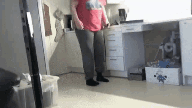 a person in a red shirt is standing in a room with a box that says ' a ' on it
