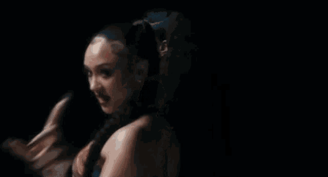 three beautiful women are standing next to each other in a dark room .