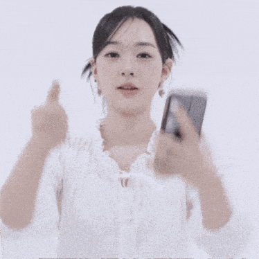 a woman giving a thumbs up while holding a phone