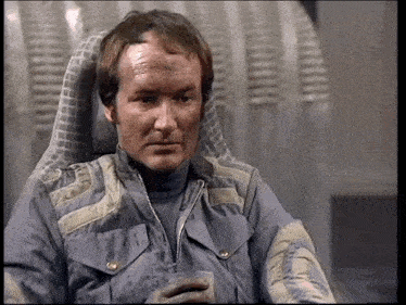 a man in a space suit is sitting in a chair holding a drink