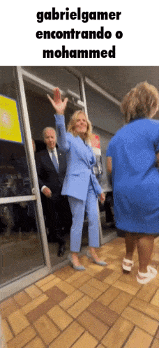 a woman in a blue suit is standing in front of a glass door