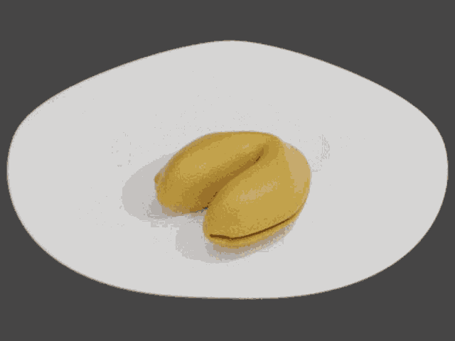 a fortune cookie on a white plate with a black background
