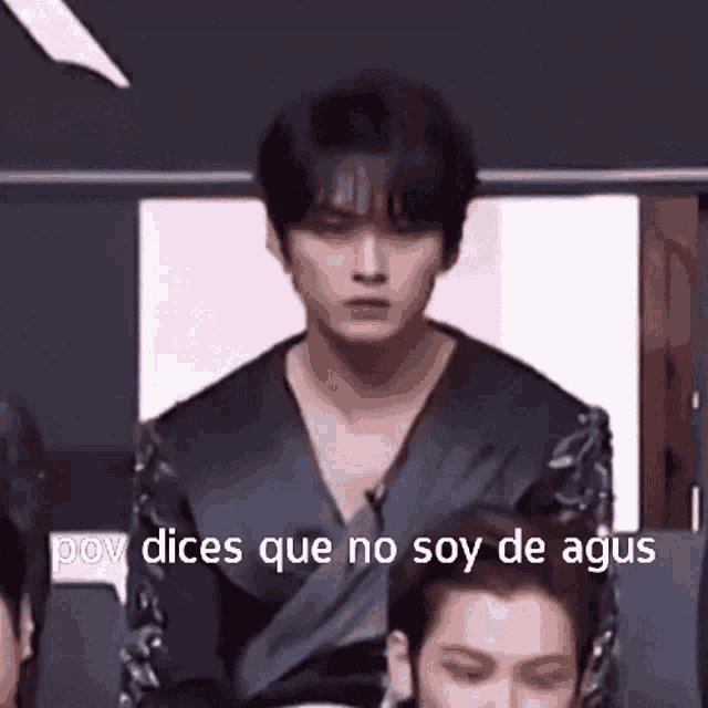a man is standing in front of a group of people and says " pov dices que no soy de agus " .