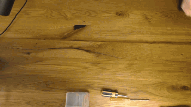 a screwdriver is sitting on a wooden table