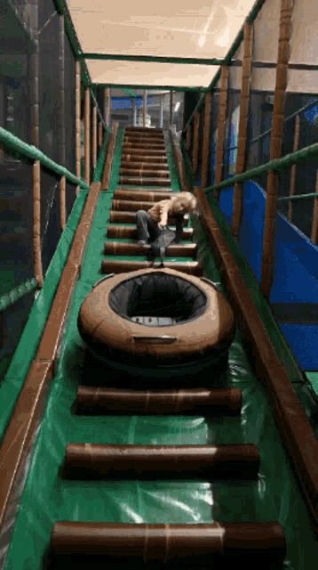 a child is playing on a slide with a tire on it