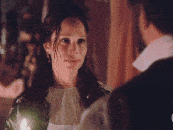 a man and a woman are looking at each other with a candle in the foreground