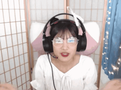 a girl wearing headphones and glasses is making a face