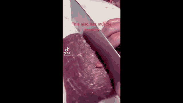 a person is cutting meat with a knife on a cutting board .