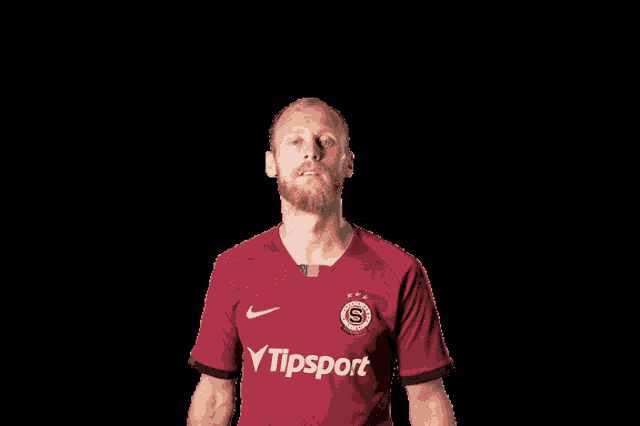 a man wearing a red shirt with the word tipsport on the front