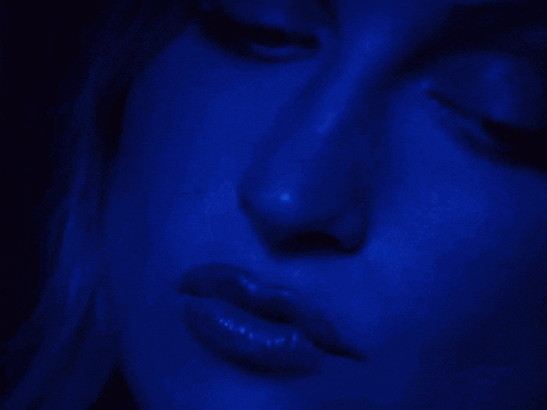 a close up of a woman 's face with a blue background