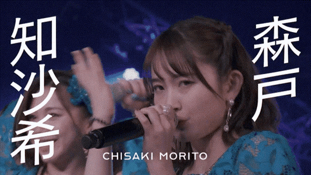 a woman singing into a microphone with the name chisaki morito on the bottom right
