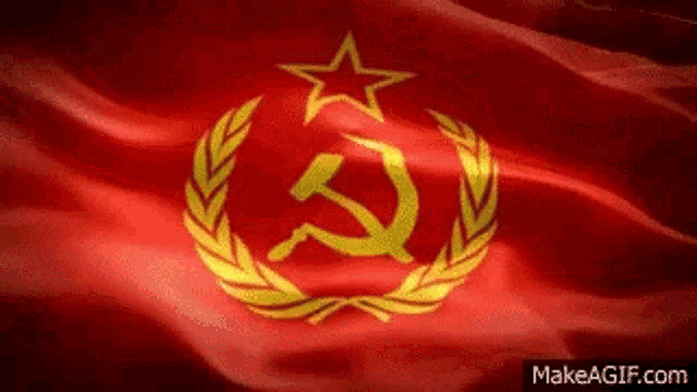 a red flag with a star , hammer and sickle , and laurel wreath waving in the wind .