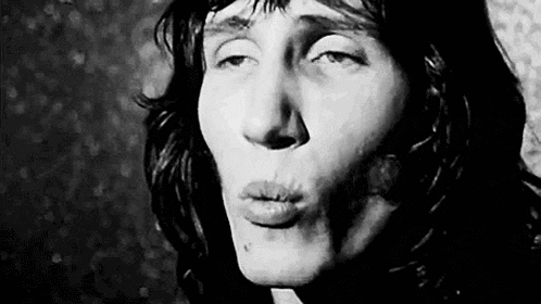a black and white photo of a man blowing a kiss with his mouth open .