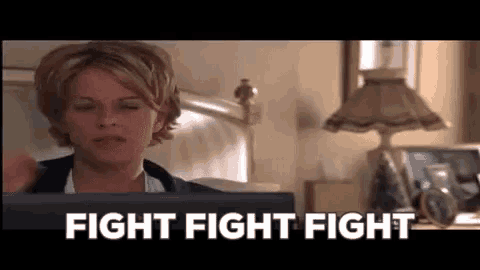 a woman is sitting in front of a computer with the words `` fight fight fight '' written on the screen .