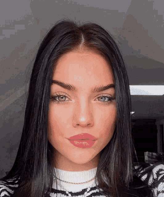 a close up of a woman 's face wearing a sweater and lipstick .