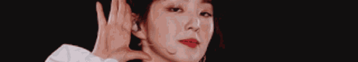 a close up of a woman making a hand gesture .