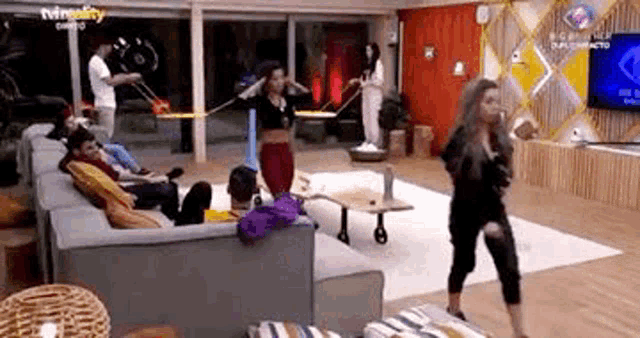 a group of people are sitting on a couch in a living room and dancing .