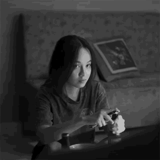 a black and white photo of a girl playing a video game with the word cool above her