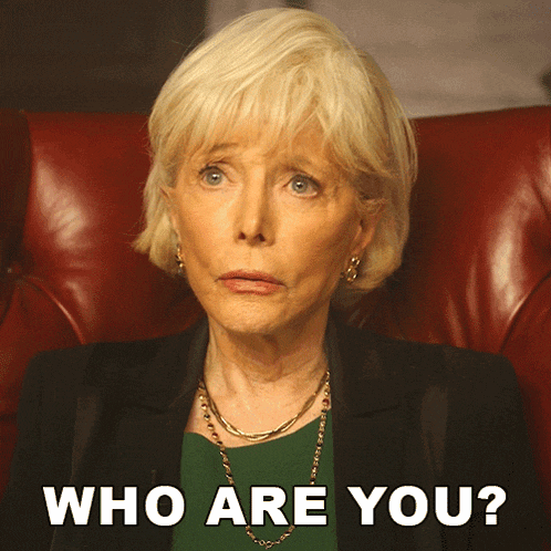 a woman with blonde hair is sitting in a red chair with the words who are you behind her
