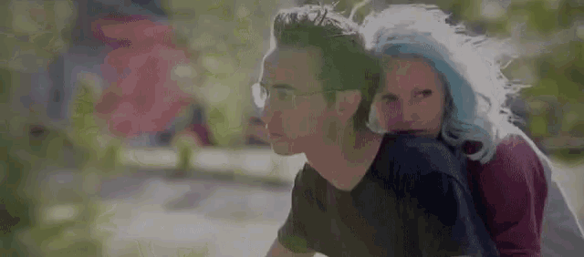 a man and a woman are sitting next to each other on a bicycle .