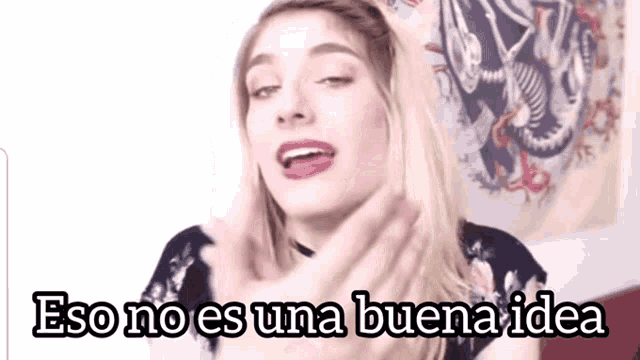 a woman says eso no es una buena idea in front of a skull tapestry