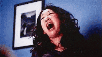 a woman is screaming with her mouth open in front of a picture frame .