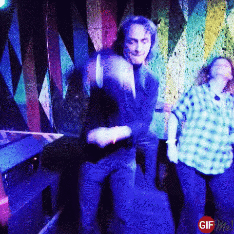 a man and a woman are dancing in a dark room with blue lights behind them .