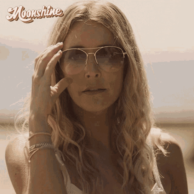 a woman wearing sunglasses with the word moonshine on the bottom