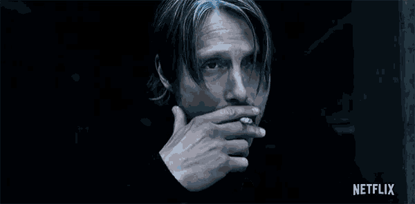 a man with a mustache is smoking a cigarette .