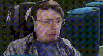 a man wearing headphones and glasses is sitting in a chair and looking at the camera .
