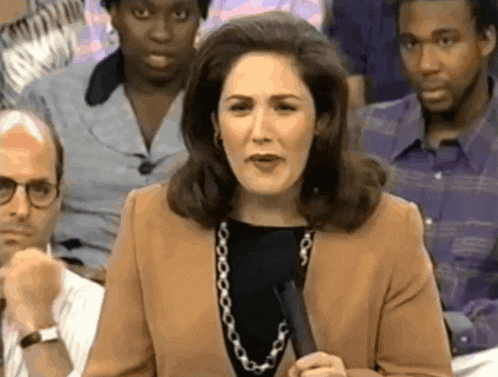 a woman is holding a microphone in front of a group of people