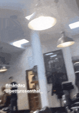 a blurred image of a salon with the hashtag #mandag