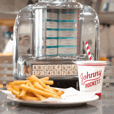 a plate of french fries and a johnny rockets drink