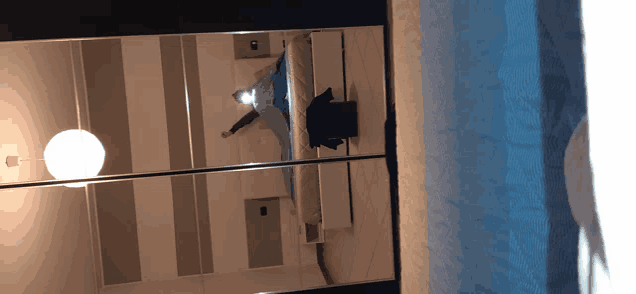 a reflection of a person laying on a bed in a mirrored room
