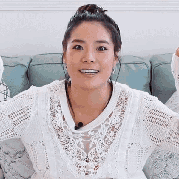 a woman says let 's make it while wearing a white sweater