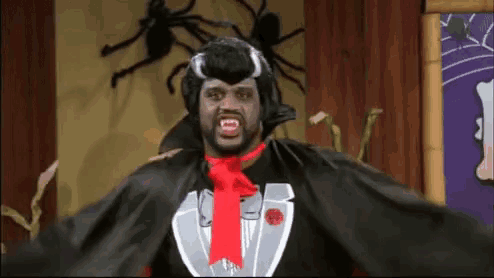 a man is dressed in a vampire costume with fangs and a red tie .