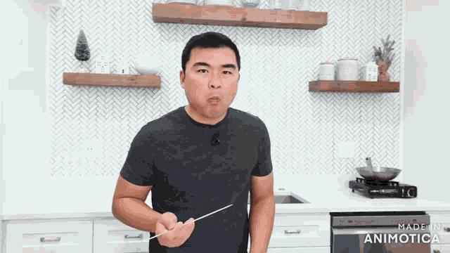 a man in a black shirt is holding a toothpick in his mouth in a kitchen made by animatica