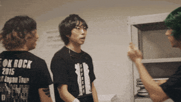 a man wearing a black shirt that says ok rock 2015 on it