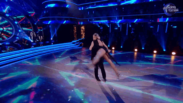 a man and a woman are dancing on a stage with dancing brasil written on the bottom